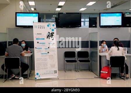 (200610) -- SHANGHAI, le 10 juin 2020 (Xinhua) -- les demandeurs d'emploi discutent avec les employeurs lors d'un salon de l'emploi dans l'est de la Chine, Shanghai, le 10 juin 2020. Les salons de carrière sur place ont été progressivement lancés à Shanghai avec l'application des mesures de prévention et de contrôle COVID-19. Dans une série récente de salons de l'emploi qui ont lieu deux fois par semaine entre le 10 et le 24 juin, les chercheurs d'emploi, y compris les étudiants diplômés, peuvent rencontrer les employeurs face à face après avoir soumis leur CV en ligne. (Xinhua/Liu Ying) Banque D'Images