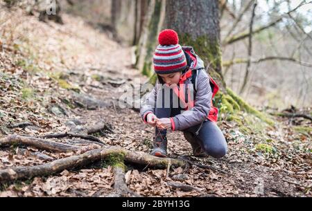 Portrait d'une fille sur la randonnée en forêt voyage nouant les lacets de chaussures. Portrait d'hiver de fille sur la randonnée familiale et moulin à eau, la famille active, les parents et les enfants Mo Banque D'Images