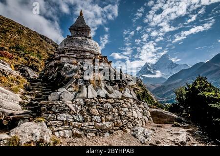 Népal. Island Peak Trek. Chorten bouddhiste avec Mani Stone Prayer Wall avec le sommet mondialement connu d'Ama Dablam dans la distance vue de la piste entre Namche Bazar et Thyangboche Banque D'Images