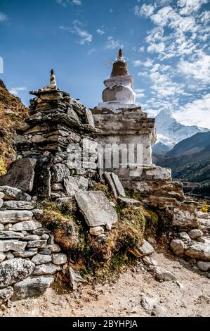 Népal. Island Peak Trek. Mur de prière en pierre de Chorten bouddhiste et de mani avec le sommet mondialement célèbre d'Ama Dablam à la distance vue du sentier entre le bazar de Namche et Thyangboche Banque D'Images