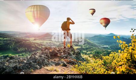 Photographe homme tient dans les mains téléphone mobile prendre des photos sur smartphone montagne avec des ballons à air chaud. Aventure touristique prise de vue sur photo Banque D'Images