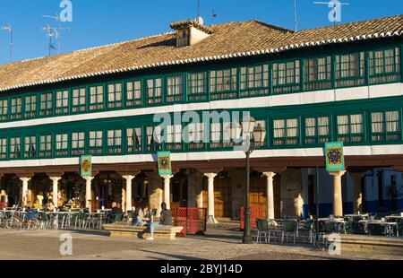 Vue partielle sur la place de la ville de la Mancha d'Almagro au coucher du soleil avec les gens et au printemps. Banque D'Images