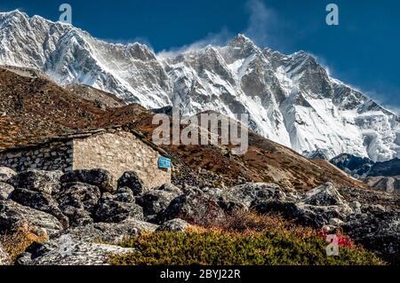 Népal. Island Peak Trek. Bâtiments périphériques près de la colonie de Sherpa de Chukhung avec le mont Everest et le mur de Lhotse au loin Banque D'Images