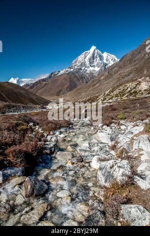 Népal. Island Peak Trek. En regardant vers le bas la vallée de l'Imja Khola en direction du village de Dingboche avec le pic formidable de Taboche au loin Banque D'Images