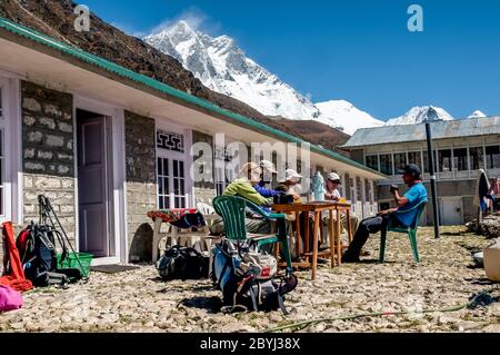 Népal. Island Peak Trek. Des randonneurs européens se détendent sur la terrasse du Lodge Valley View à la colonie Sherpa de Dingboche Banque D'Images