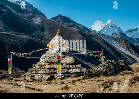 Népal. Island Peak Trek. Au Chorten Stupa bouddhiste, au-dessus de la colonie de Sherpa de Dingboche, regardant dans la direction du célèbre pic d'Ama Dablam et du pic voisin de Kangtega Banque D'Images