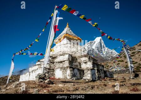 Népal. Island Peak Trek. Au Chorten bouddhiste Stupa au-dessus de la colonie Sherpa de Dingboche avec le formidable pic de Taboche au loin Banque D'Images