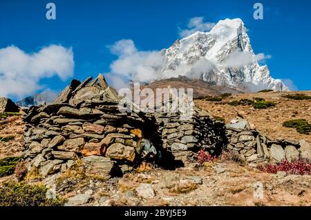 Népal. Island Peak Trek. Mani bouddhiste mur de prière en pierre avec le pic formidable de Taboche depuis le dessus du village de Dingboche Banque D'Images