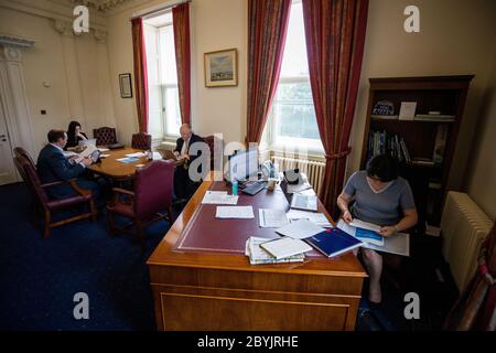 Dans les coulisses de Stormont, lors de la pandémie Covid-19, la première ministre Arlene Foster (à droite) est présente dans son bureau avec son ministre junior Gordon Lyons (à gauche), et les SPAD Emma Little-Pengelly (à gauche) et le Dr Phillip Weir (au centre). Banque D'Images