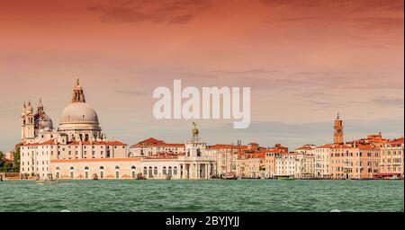 Vue colorée sur la basilique Santa Maria della Salute et le Grand Canal animé au coucher du soleil, Venise, Italie Banque D'Images