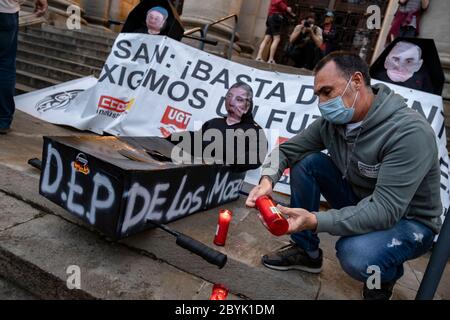 Un travailleur de Nissan est vu allumer des bougies devant les coffres symboliques des dirigeants et PDG de Nissan pendant les manifestations.des travailleurs du constructeur automobile japonais ont effectué une marche nocturne à Barcelone pour visualiser les plus de 20,000 emplois menacés par la fermeture de la production Usine dans la Zona Franca (Barcelone). Banque D'Images