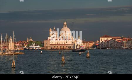 Vue colorée sur la basilique Santa Maria della Salute et le Grand Canal animé au coucher du soleil, Venise, Italie Banque D'Images