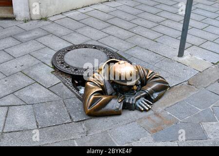 Bratislava, Slovaquie - 21 juillet 2019 : sculpture en bronze en tant qu'homme regardant depuis un trou d'homme dans la zone piétonne de la capitale Banque D'Images