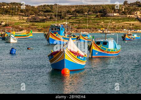 Bateaux colorés au port de pêche de Marsaxlokk, dans le sud-est de Malte. Il y a des ports grands et imposants comme celui de la capitale Valetta, mais de petits ports de pêche caractérisent la côte variée de Malte et de Gozo Banque D'Images