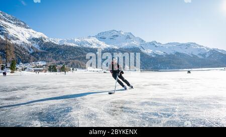 Patinage sur glace dans la nature. Vue panoramique panoramique sur la silhouette d'un jeune joueur de hockey qui glisse sur un lac gelé. Voyages et sports. Lac de Saint Banque D'Images