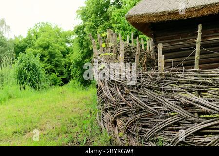 Clôture rurale en bois dans le village près de la maison près de la forêt. Authentique culture traditionnelle dans l'architecture et la vie. Lumière du soleil, vieux bâtiments en bois i Banque D'Images
