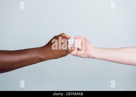 Gros plan photo de deux mains armes race différente amis multinationaux antiracisme question aider ensemble tenir les petits doigts copains ensemble le monde Banque D'Images