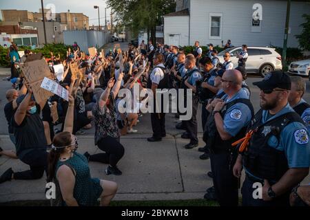 Les policiers de Chicago sont en face avec les manifestants au 24e District police Station, dans le quartier du Rogers Park, à l'extrême nord, le 3 juin 2020. Après un rassemblement communautaire en faveur de la Black Lives Matter, environ 200 manifestants ont poursuivi la manifestation en marchant jusqu'au poste de police de Clark Street où s'est ensuivie une impasse tendue de 30 minutes devant le bâtiment. Les manifestants ont scandé « dites leurs noms », « pas de justice, pas de paix » et d'autres slogans. La ligne des policiers était toujours là et ne disait rien en retour. Finalement, les manifestants se sont enrarés et ont continué à marcher vers le sud sur la rue Clark Banque D'Images