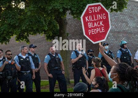 Les policiers de Chicago sont en face avec les manifestants au 24e District police Station, dans le quartier du Rogers Park, à l'extrême nord, le 3 juin 2020. Après un rassemblement communautaire en faveur de la Black Lives Matter, environ 200 manifestants ont poursuivi la manifestation en marchant jusqu'au poste de police de Clark Street où s'est ensuivie une impasse tendue de 30 minutes devant le bâtiment. Les manifestants ont scandé « dites leurs noms », « pas de justice, pas de paix » et d'autres slogans. La ligne des policiers était toujours là et ne disait rien en retour. Finalement, les manifestants se sont enrarés et ont continué à marcher vers le sud sur la rue Clark Banque D'Images