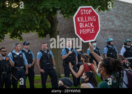 Les policiers de Chicago sont en face avec les manifestants au 24e District police Station, dans le quartier du Rogers Park, à l'extrême nord, le 3 juin 2020. Après un rassemblement communautaire en faveur de la Black Lives Matter, environ 200 manifestants ont poursuivi la manifestation en marchant jusqu'au poste de police de Clark Street où s'est ensuivie une impasse tendue de 30 minutes devant le bâtiment. Les manifestants ont scandé « dites leurs noms », « pas de justice, pas de paix » et d'autres slogans. La ligne des policiers était toujours là et ne disait rien en retour. Finalement, les manifestants se sont enrarés et ont continué à marcher vers le sud sur la rue Clark Banque D'Images