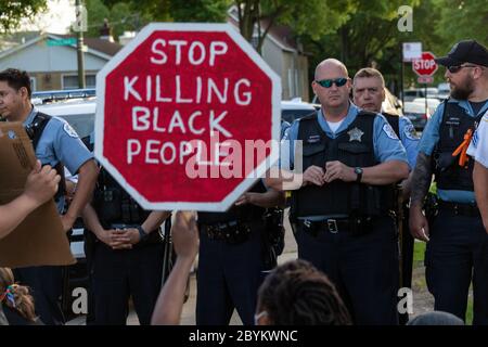 Les policiers de Chicago sont en face avec les manifestants au 24e District police Station, dans le quartier du Rogers Park, à l'extrême nord, le 3 juin 2020. Après un rassemblement communautaire en faveur de la Black Lives Matter, environ 200 manifestants ont poursuivi la manifestation en marchant jusqu'au poste de police de Clark Street où s'est ensuivie une impasse tendue de 30 minutes devant le bâtiment. Les manifestants ont scandé « dites leurs noms », « pas de justice, pas de paix » et d'autres slogans. La ligne des policiers était toujours là et ne disait rien en retour. Finalement, les manifestants se sont enrarés et ont continué à marcher vers le sud sur la rue Clark Banque D'Images