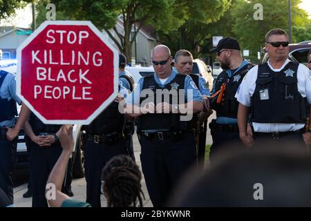 Les policiers de Chicago sont en face avec les manifestants au 24e District police Station, dans le quartier du Rogers Park, à l'extrême nord, le 3 juin 2020. Après un rassemblement communautaire en faveur de la Black Lives Matter, environ 200 manifestants ont poursuivi la manifestation en marchant jusqu'au poste de police de Clark Street où s'est ensuivie une impasse tendue de 30 minutes devant le bâtiment. Les manifestants ont scandé « dites leurs noms », « pas de justice, pas de paix » et d'autres slogans. La ligne des policiers était toujours là et ne disait rien en retour. Finalement, les manifestants se sont enrarés et ont continué à marcher vers le sud sur la rue Clark Banque D'Images