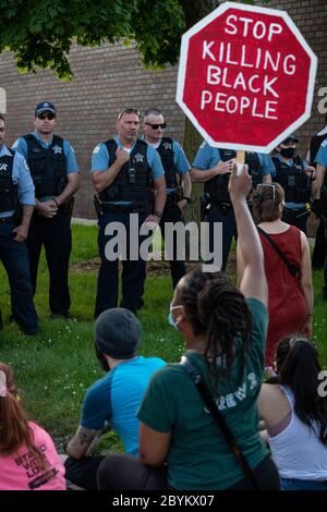 Les policiers de Chicago sont en face avec les manifestants au 24e District police Station, dans le quartier du Rogers Park, à l'extrême nord, le 3 juin 2020. Après un rassemblement communautaire en faveur de la Black Lives Matter, environ 200 manifestants ont poursuivi la manifestation en marchant jusqu'au poste de police de Clark Street où s'est ensuivie une impasse tendue de 30 minutes devant le bâtiment. Les manifestants ont scandé « dites leurs noms », « pas de justice, pas de paix » et d'autres slogans. La ligne des policiers était toujours là et ne disait rien en retour. Finalement, les manifestants se sont enrarés et ont continué à marcher vers le sud sur la rue Clark Banque D'Images