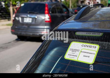 22 mai 2020 - Montréal, Québec, Canada : COVID-19 autocollant spécial permis de stationnement pour les travailleurs de la santé sur une fenêtre de voiture, rue résidentielle Banque D'Images