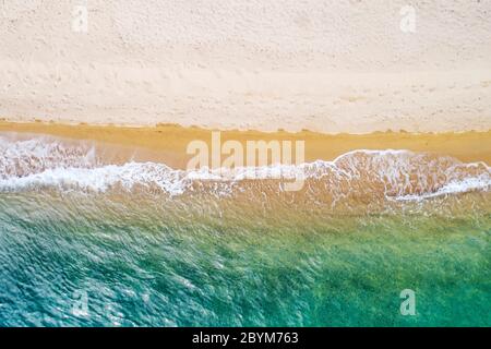 Vue aérienne de la plage de Lagomandra sur la péninsule de Sithonia, dans le Chalkidiki, Grèce. Plage et vagues depuis la vue de dessus. Fond turquoise de Banque D'Images