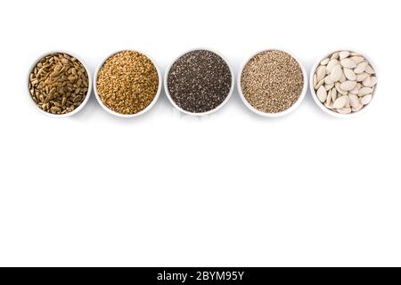 Assortiment de différents grains dans bol isolé sur fond blanc. Citrouille, lin, Chia, de tournesol, et de graines de sésame Banque D'Images