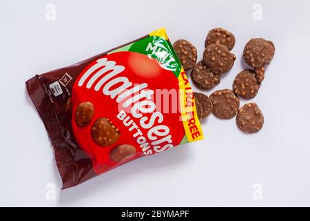 Paquet de nouveaux boutons Mint Maltesers ouvert avec le contenu renversé isolé sur fond blanc - chocolat au lait aromatisé à la menthe avec des morceaux de miel Banque D'Images