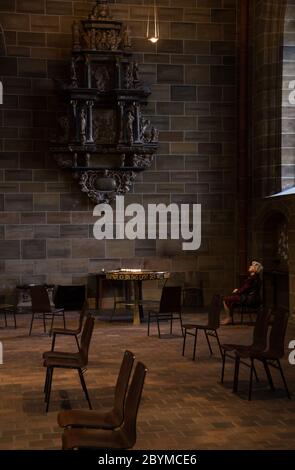 14.05.2020, Brême, Brême, Allemagne - dame plus âgée cherchant le confort dans les temps de corona dans la cathédrale Saint-Pierre, chaises devant à distance de corona. 00A2 Banque D'Images