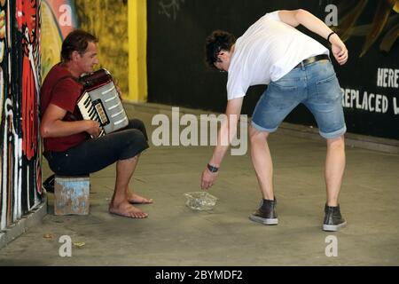 20.07.2018, Tbilissi, Géorgie - Passer-by donne de l'argent à un musicien de rue. 00S180720D059CAROEX.JPG [AUTORISATION DU MODÈLE : NON, AUTORISATION DU PROPRIÉTAIRE : NON (C) CARO Banque D'Images