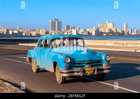 Taxi dans une voiture américaine classique d'époque qui longe El Malecon, la Havane, Cuba Banque D'Images