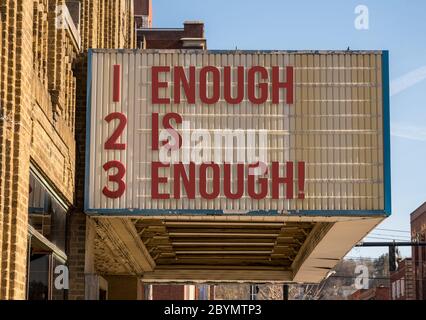 Une maquette de panneau d'affichage de cinéma avec un message de assez est suffisante sur le panneau de marquise dans la rue du centre-ville Banque D'Images