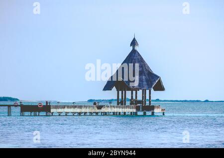 Jetée de plage aux Maldives au lever du soleil entourée d'eau turquoise Banque D'Images