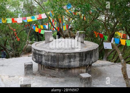 Bunker en béton historique entouré de drapeaux de prière tibétains. À l'intérieur du parc du temple bouddhiste de Nanputuo. Banque D'Images