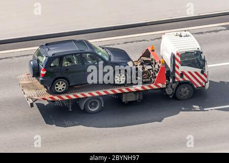 Un camion-dépanneur transporte une voiture évacuée sur une autoroute, vue aérienne Banque D'Images