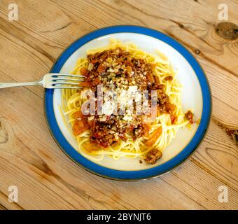 Cuisine italienne Spaghetti bolognaise à base de bœuf haché et de sauce tomate, nappée de fromage et de poivre noir sur une table en bois Banque D'Images