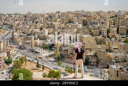 Homme regardant le centre-ville d'Amman avec le drapeau de Jordanie en arrière-plan Banque D'Images