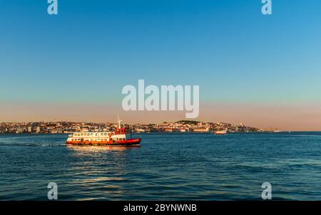 Ferry pour passagers de Lisbonne traversant le Tage en direction d'Almada au coucher du soleil avec Lisbonne paysage urbain en arrière-plan. Banque D'Images