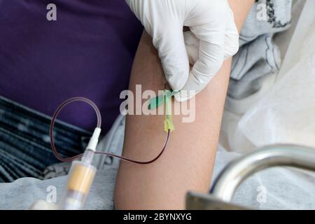 L'infirmière prélève un échantillon de sang d'un patient pour un test sanguin en raison d'un cas possible de coronavirus covid-19 Banque D'Images