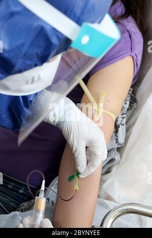 L'infirmière prélève un échantillon de sang d'un patient pour un test sanguin en raison d'un cas possible de coronavirus covid-19 Banque D'Images