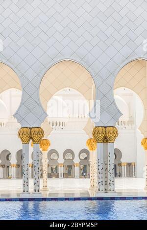 Couloir avec piliers dorés à l'entrée de la célèbre mosquée Sheikh Sultan Zayed à Abu Dhabi, Émirats Arabes Unis Banque D'Images