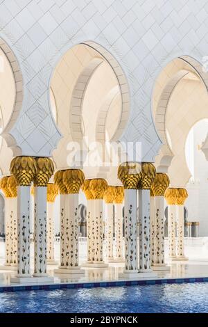 Couloir avec piliers dorés à l'entrée de la célèbre mosquée Sheikh Sultan Zayed à Abu Dhabi, Émirats Arabes Unis Banque D'Images