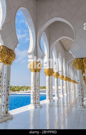 Couloir avec piliers dorés à l'entrée de la célèbre mosquée Sheikh Sultan Zayed à Abu Dhabi, Émirats Arabes Unis Banque D'Images