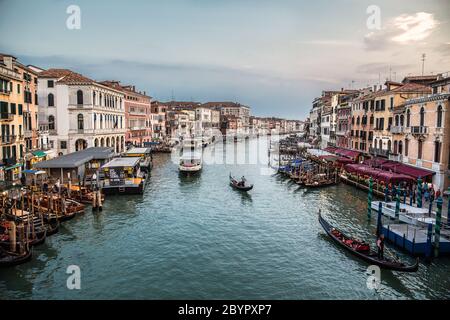 Gondoles traditionnelles, bateaux à passagers modernes, Canal Grande et de beaux bâtiments de la vieille ville vus du pont du Rialto au coucher du soleil, Venise, Ital Banque D'Images