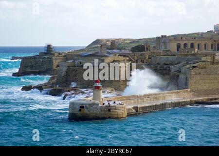 VALLETTA, MALTE - 31 décembre 2019 : vue du fort St Elmo sur le Grand Port de Ricasoli, brise-lames et phare rouge pendant les vagues fortes Banque D'Images