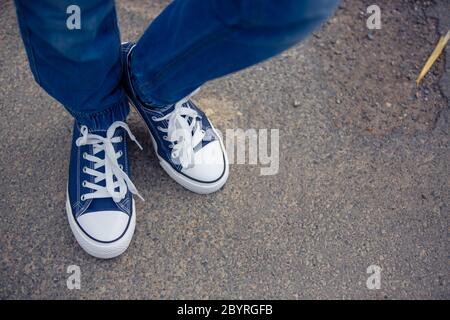 Pieds pour enfants dans de nouvelles baskets bleues sur la rue Banque D'Images