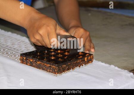 Procédé de timbre de cire Batik dans l'usine Winotosastro de Yogyakarta, Java, Indonésie. Motifs batik sur tissu. Il représente des symboles floraux. Banque D'Images